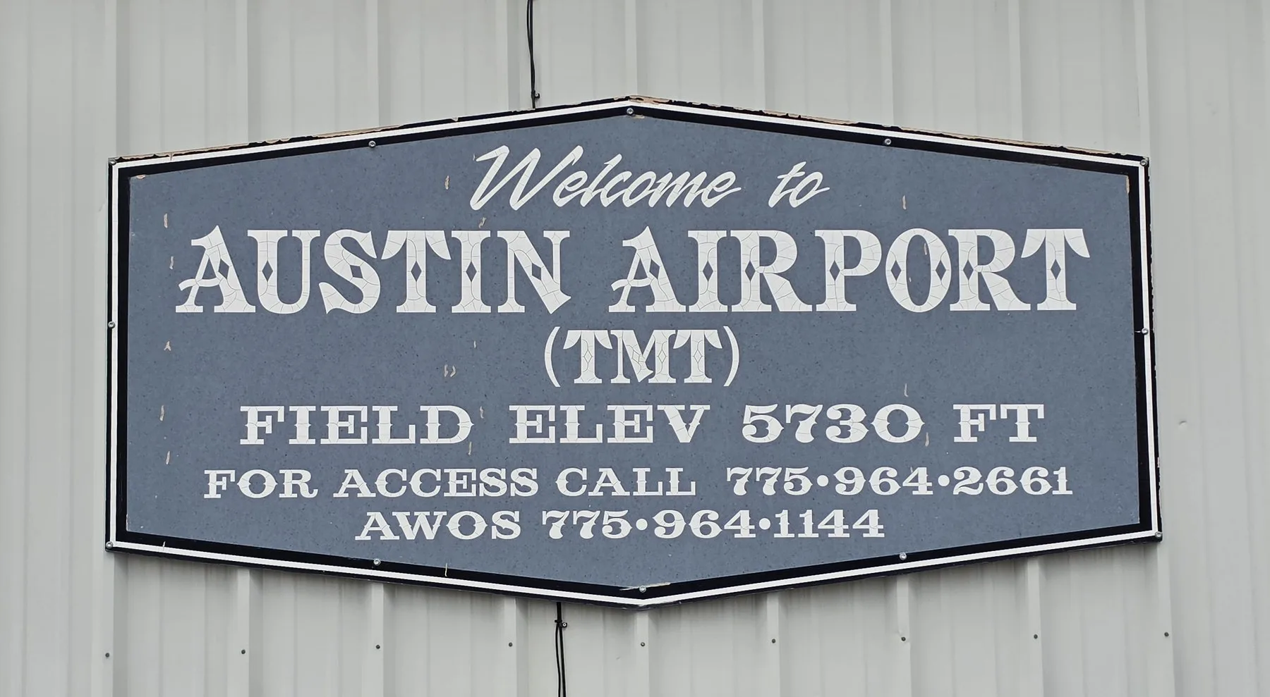 Welcome to Austin Airport (TMT) sign, field elevation 5730 ft, mounted on the FBO building
